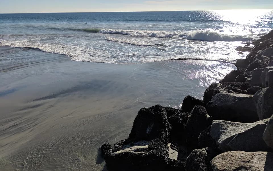 Surf breaking along the harbor jetty rocks